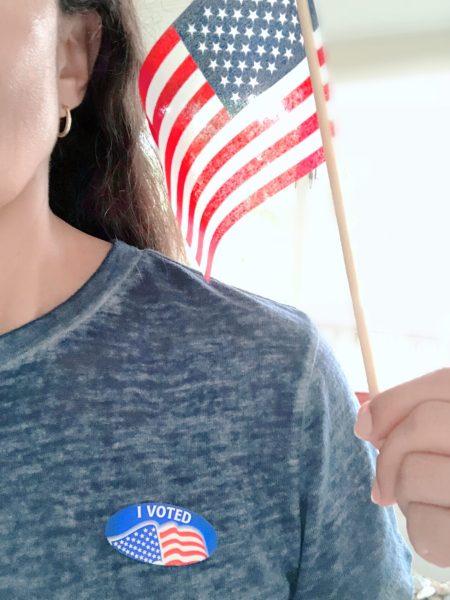 latino-woman-wearing-a-sticker-with-i-voted-prin-2023-11-27-05-19-10-utc-min